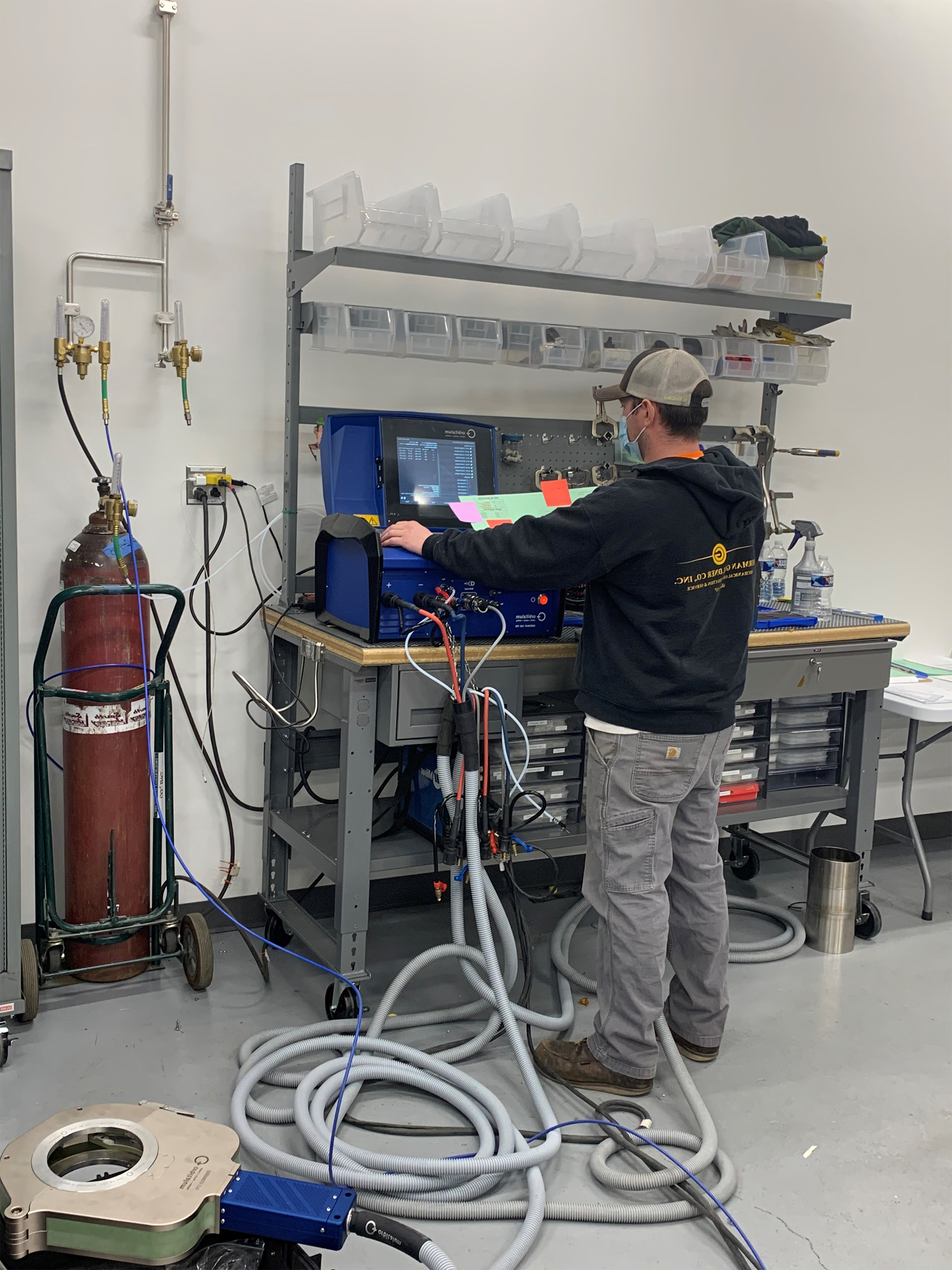 Technician testing high-purity sanitary process piping at Herman Goldner Co., Inc. cleanroom facility, ensuring pharmaceutical-grade fabrication, CAD support, and regulatory compliance.